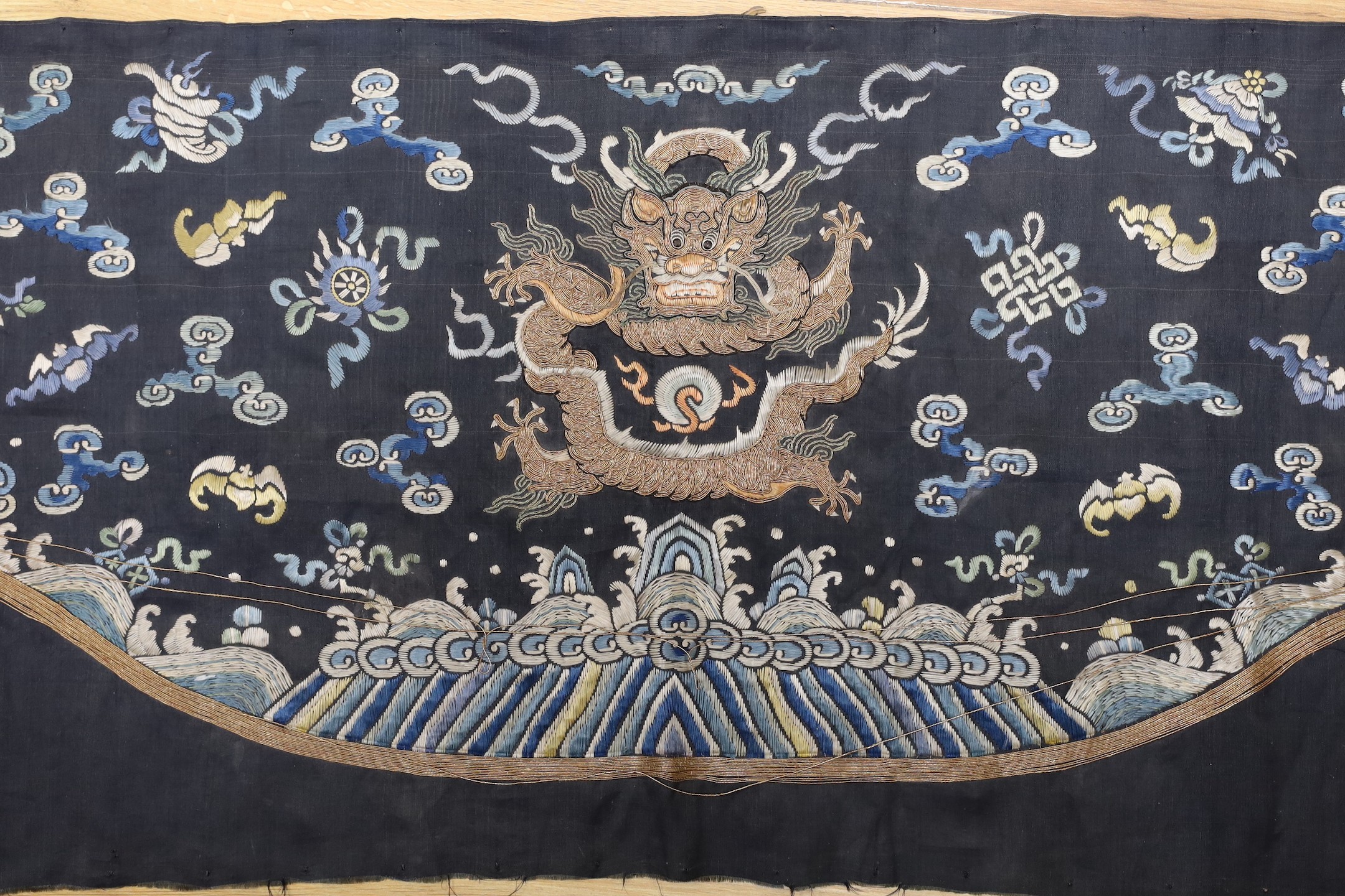 A Chinese late 19th century embroidery of a dragon, probably from a Chinese robe or hanging 37x105cm